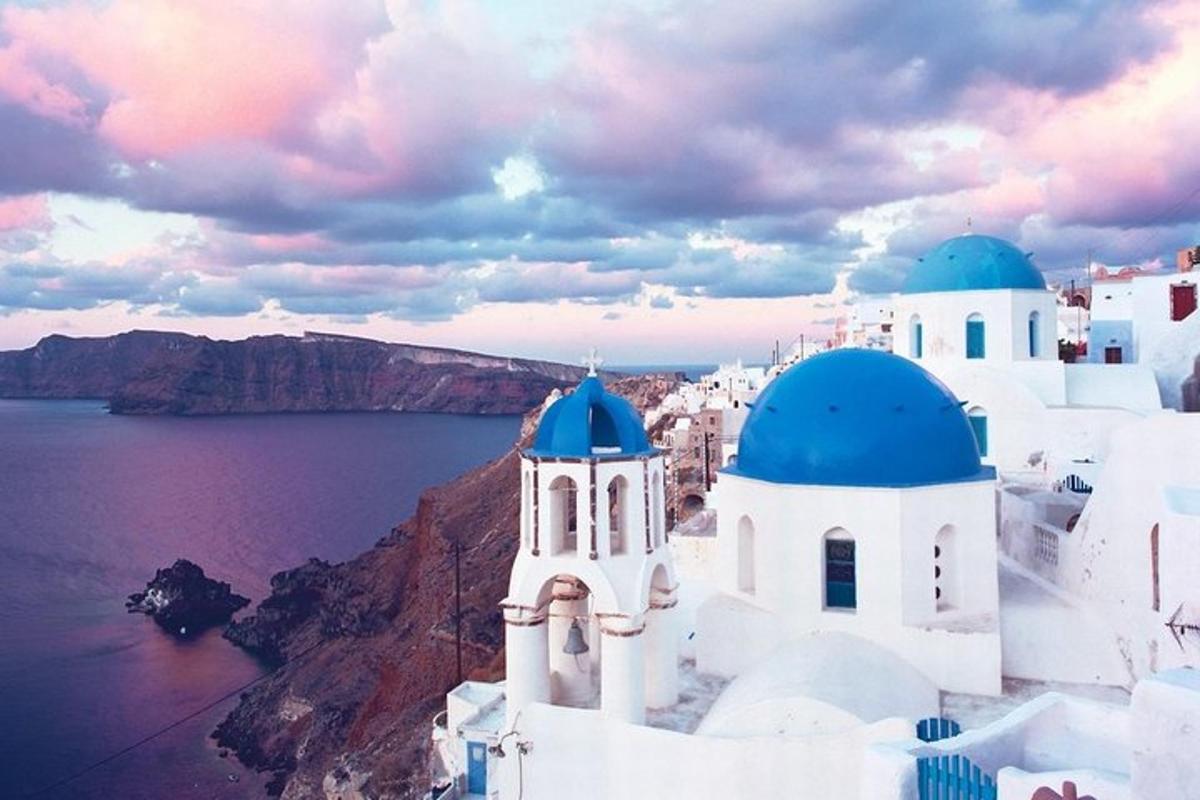 Un grupo de edificios blancos con cúpulas azules en un acantilado