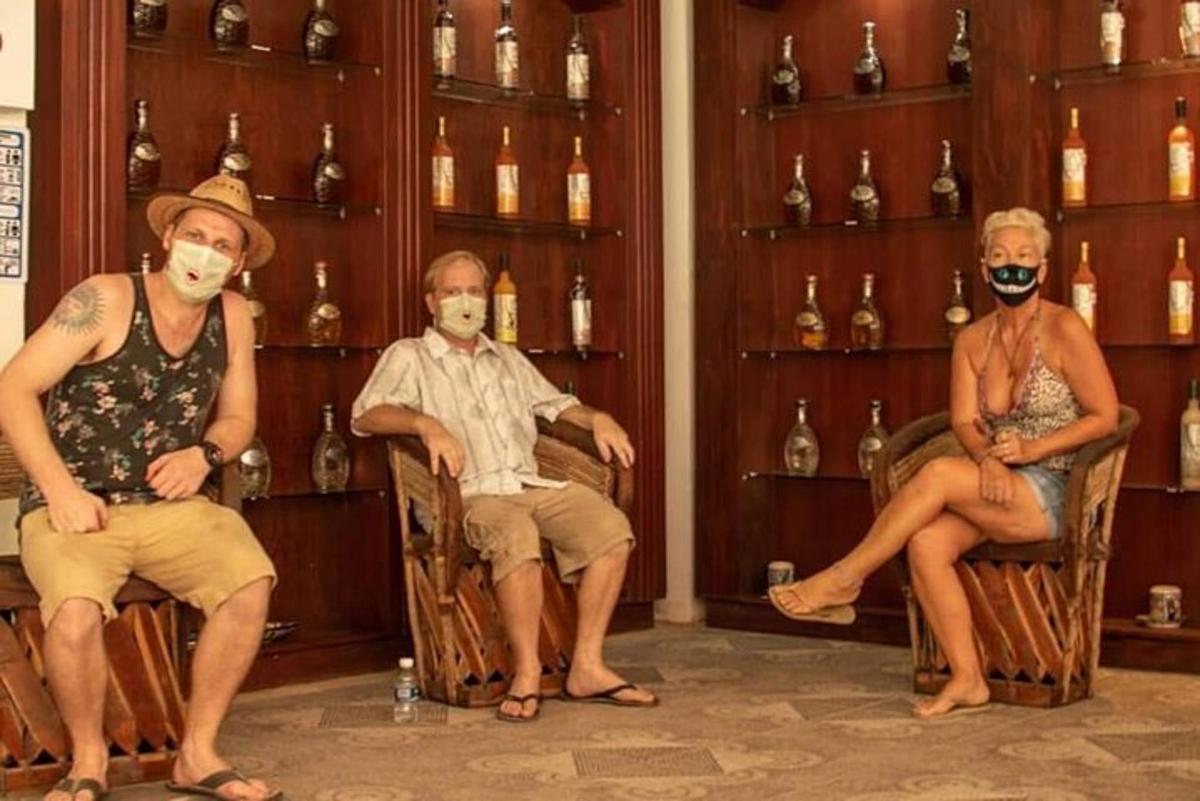 skupina lidí sedících na židlích v místnosti s lahvemi