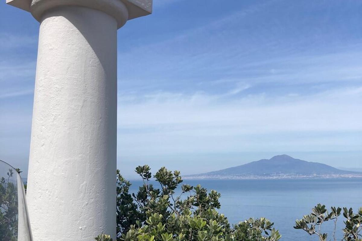 μια λευκή κολόνα με θέα στον ωκεανό
