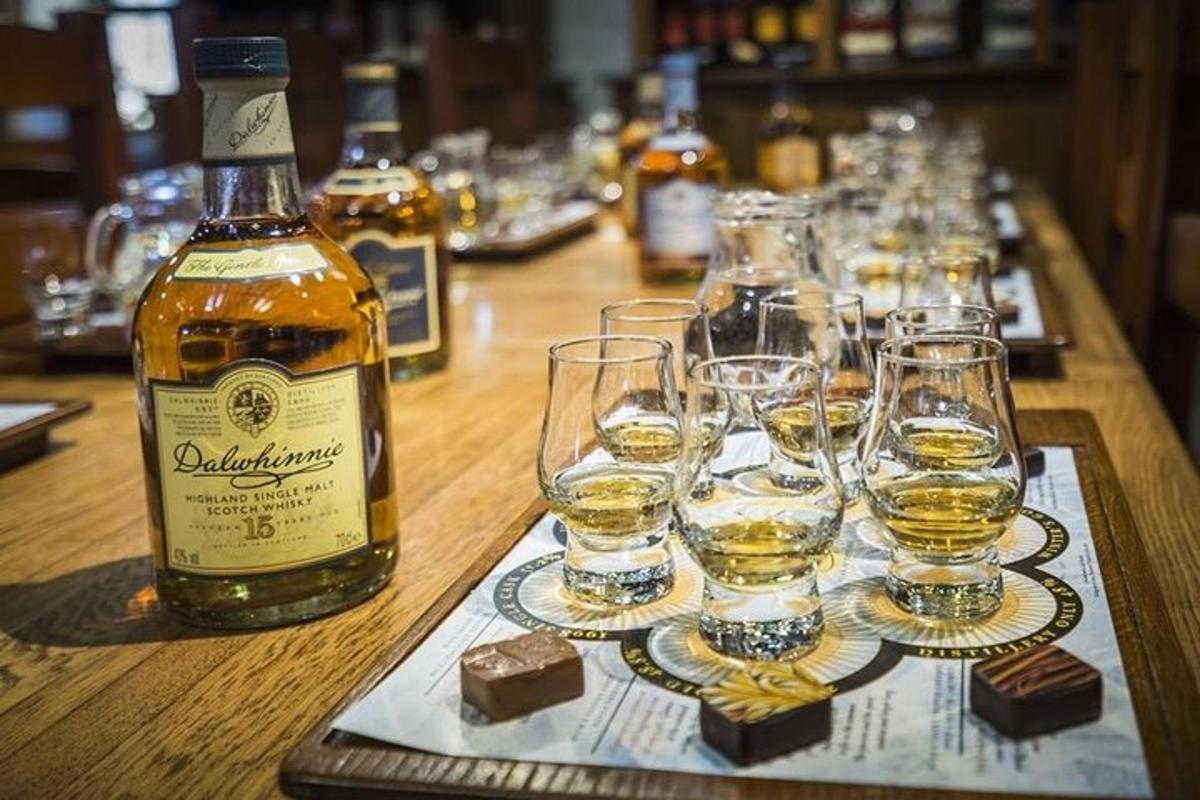 dlhý drevený stôl s pohármi a fľašami alkoholu
