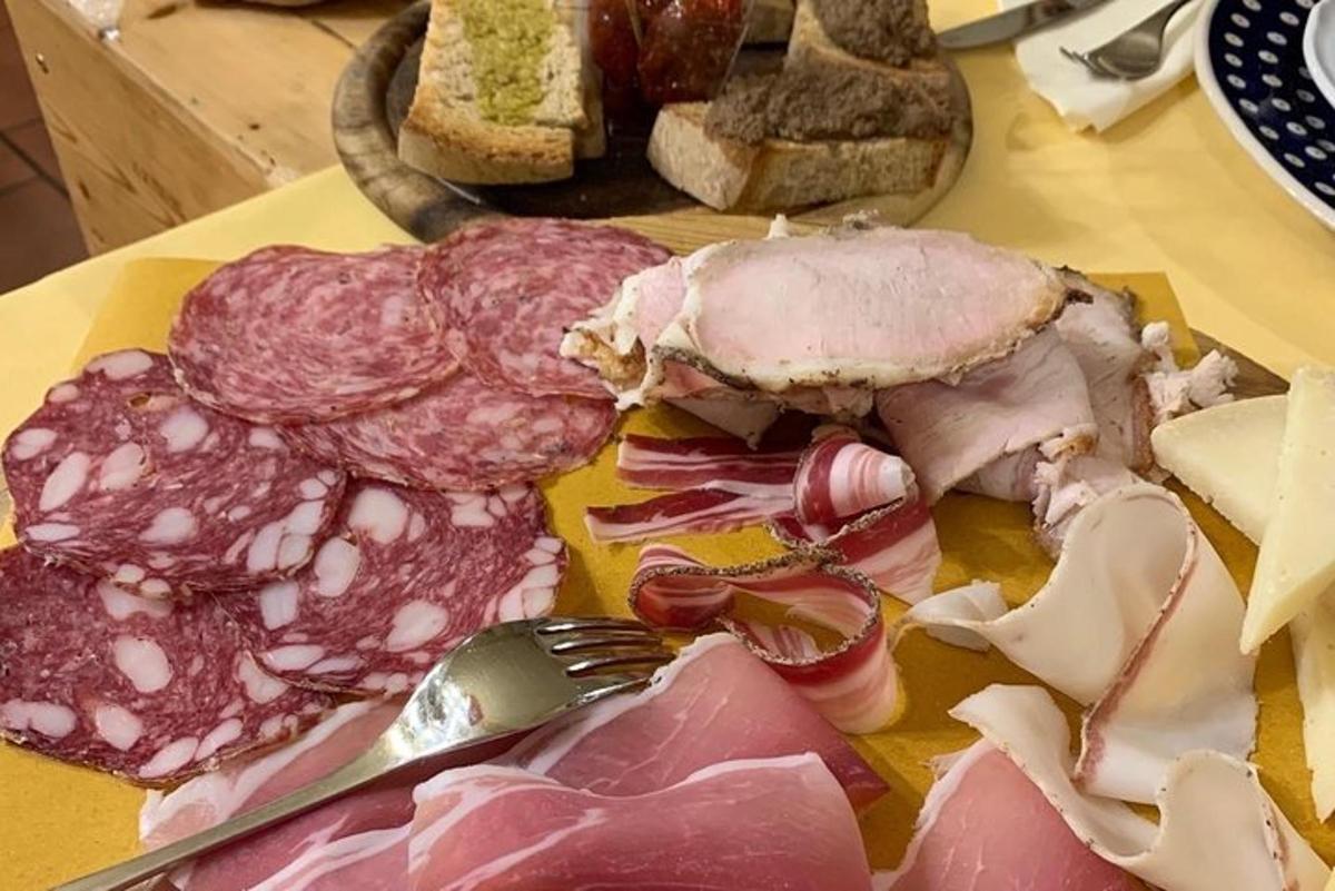 un panino con carne e formaggio su un tavolo con una forchetta