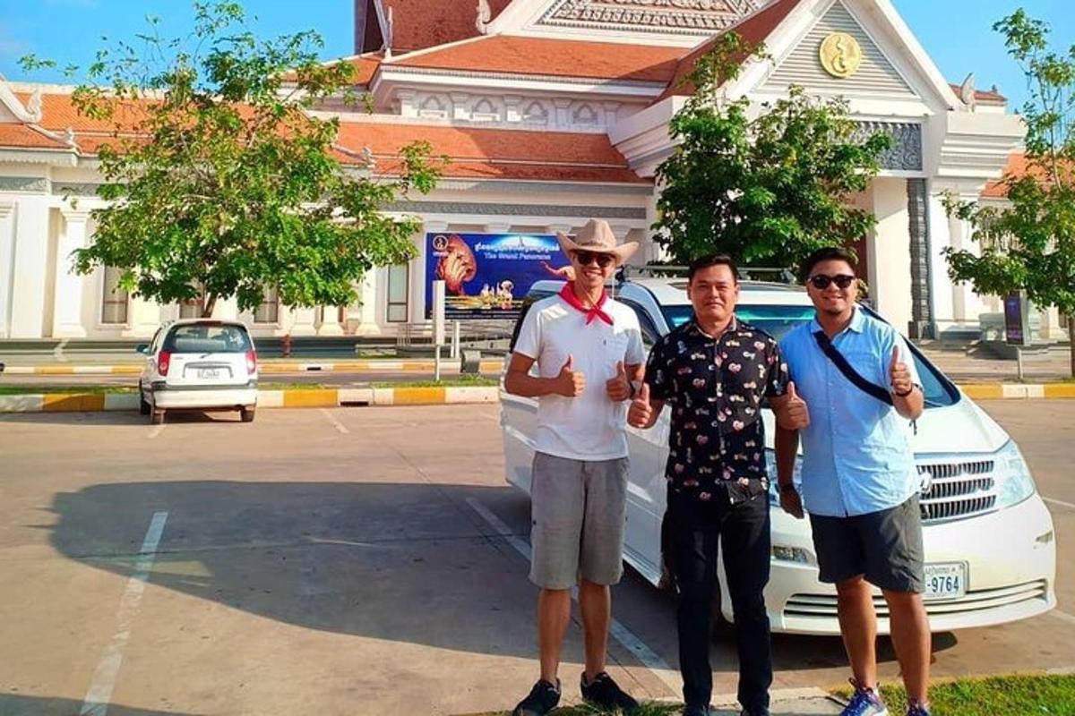 Un grupo de tres hombres de pie junto a un coche.