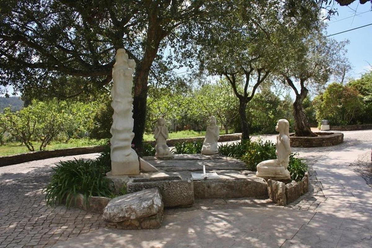 a garden with statues and rocks and trees