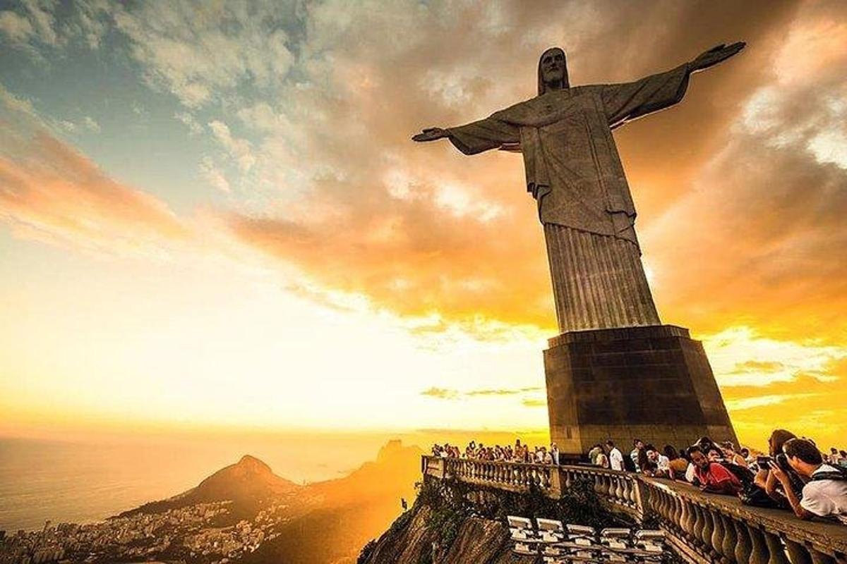 un gruppo di persone in piedi attorno alla statua del Cristo Redentore