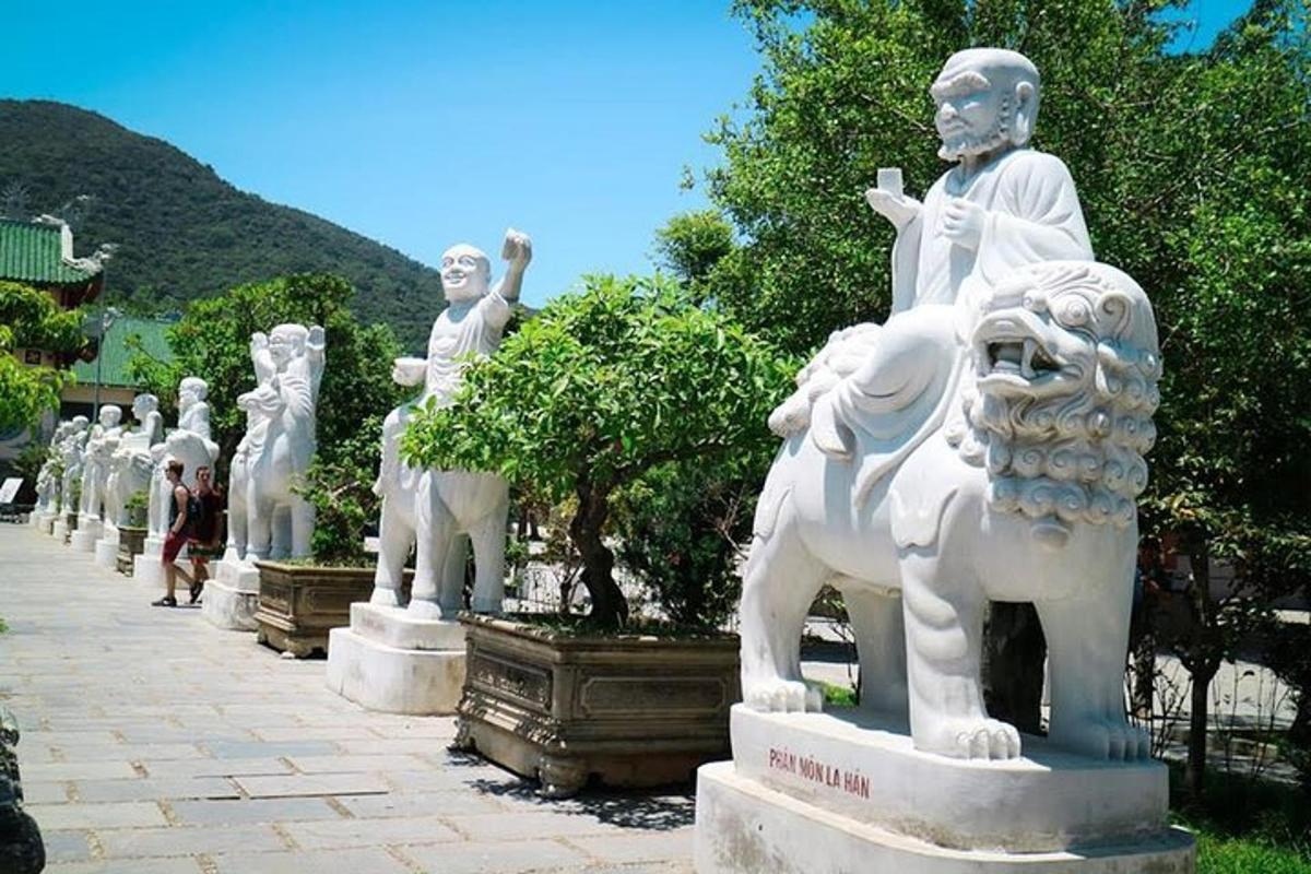 a row of white statues in a park