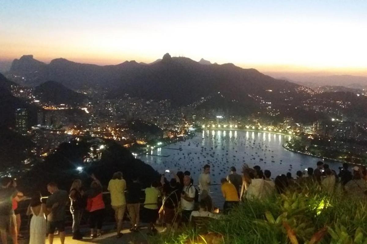 Un grupo de personas de pie en una colina con vistas a un lago.