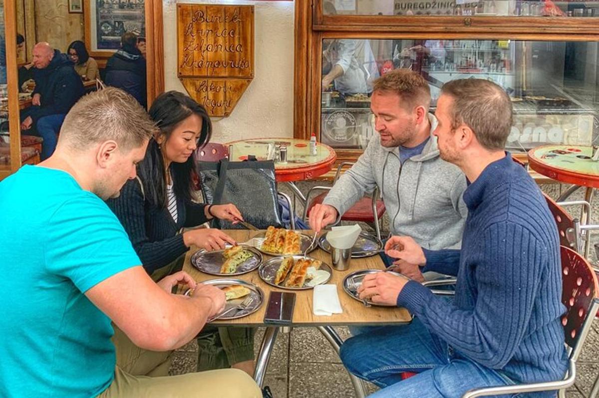skupina lidí sedících kolem stolu a jedících jídlo