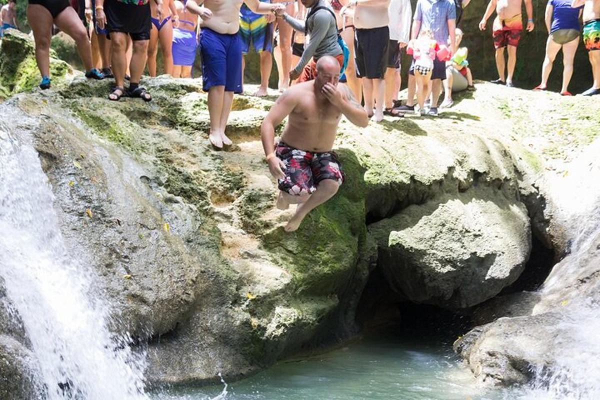 un uomo che salta in una cascata davanti a una folla di persone