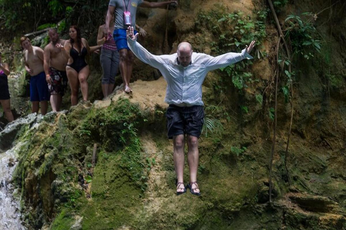 seorang pria berdiri di atas batu dengan kedua tangannya terentang