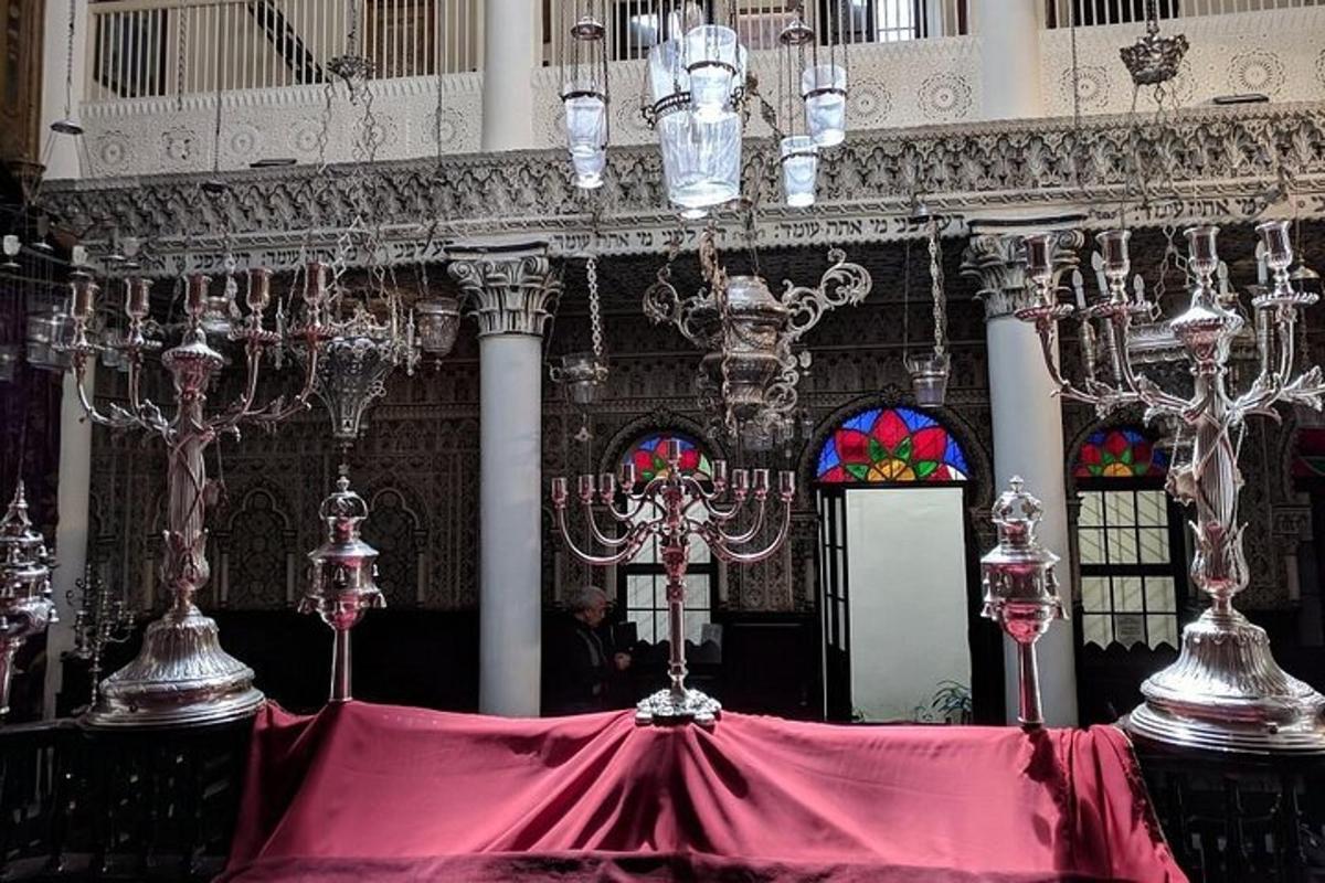 ένα δωμάτιο με πολυελαίους και ένα τραπέζι με ένα κόκκινο πανί