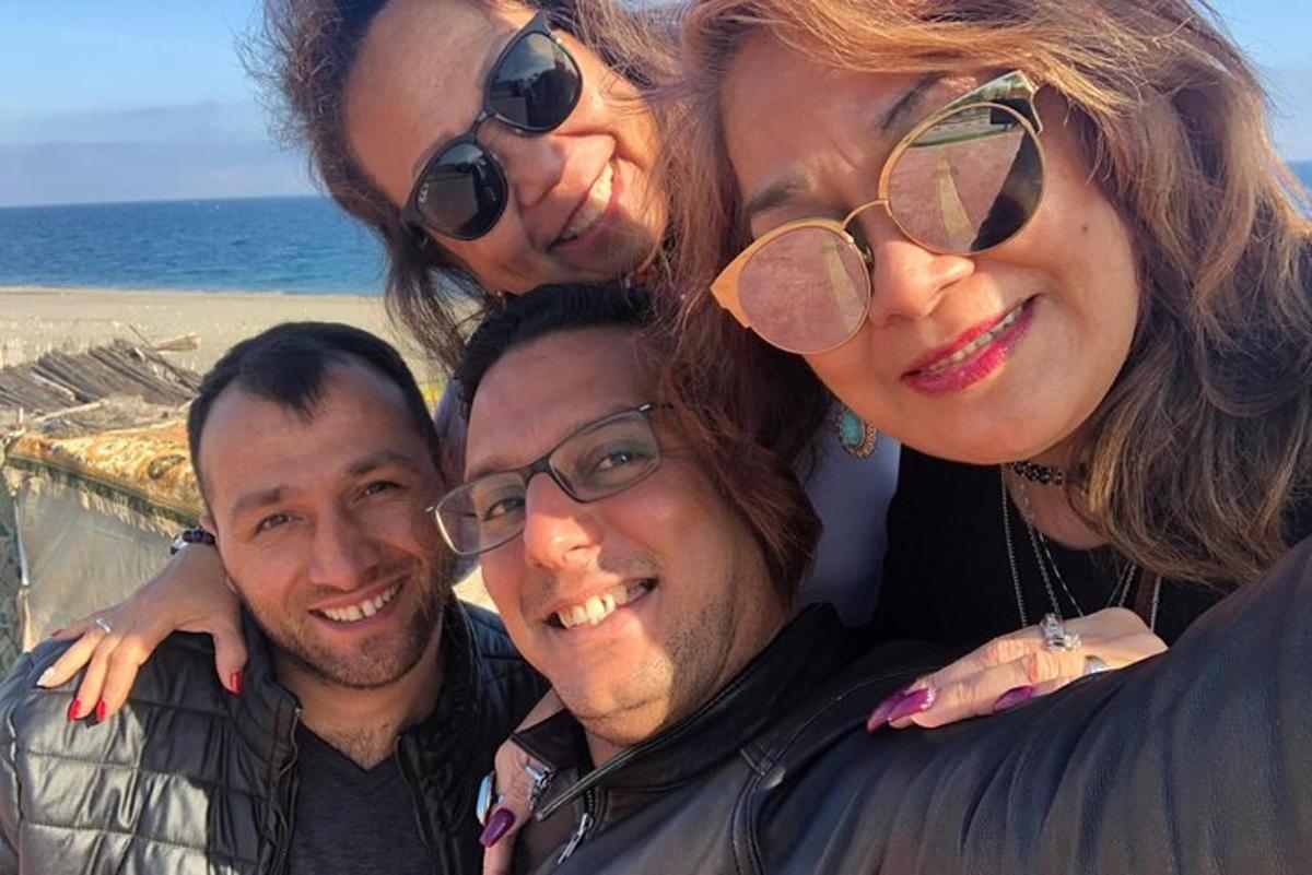 μια ομάδα ανθρώπων που ποζάρουν για μια φωτογραφία στην παραλία