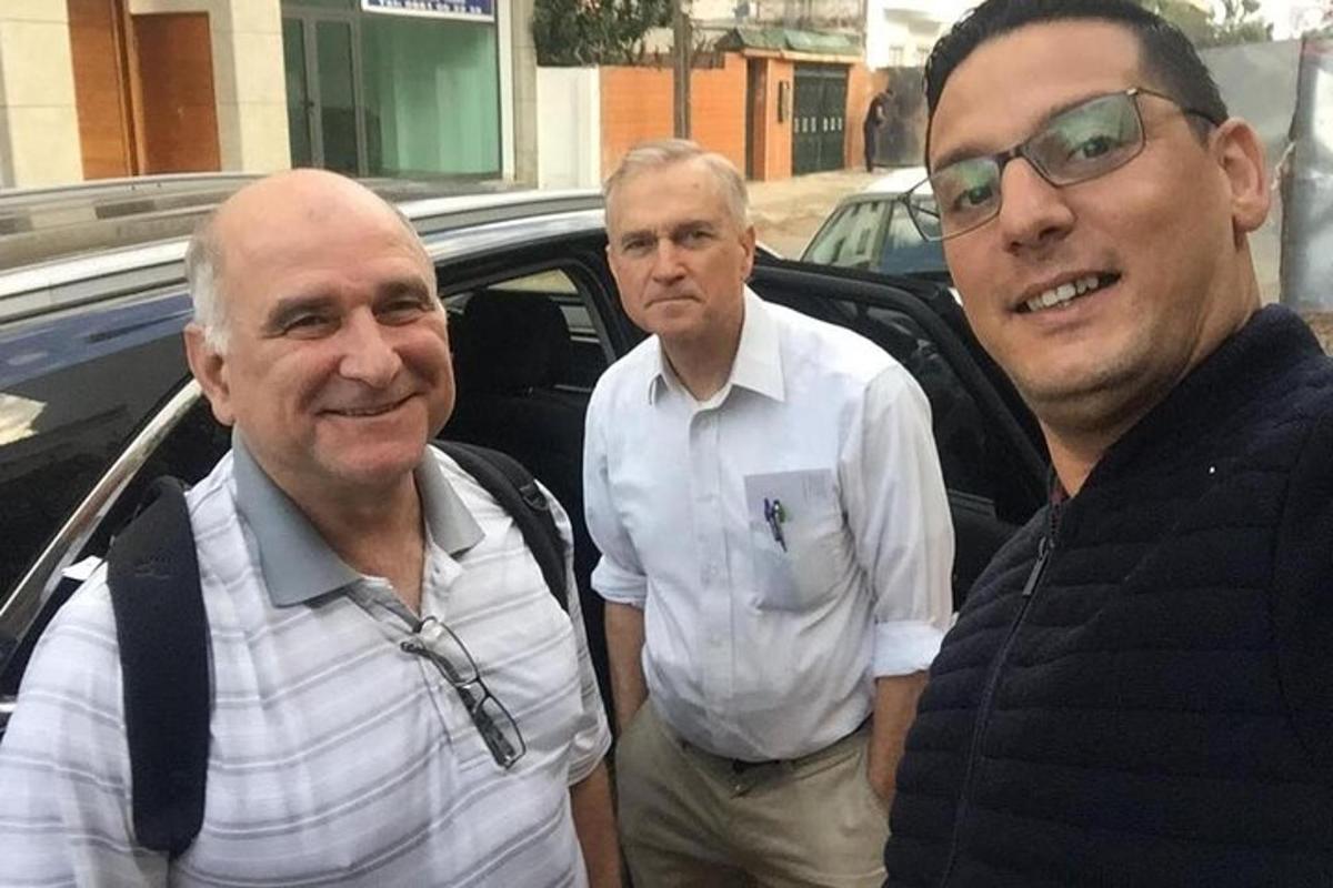 τρεις άντρες που στέκονται μπροστά από ένα αυτοκίνητο