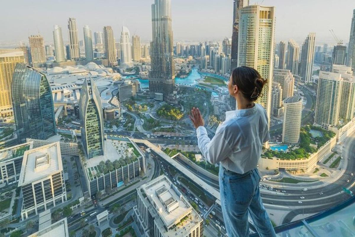 a woman standing on top of a building looking at a city
