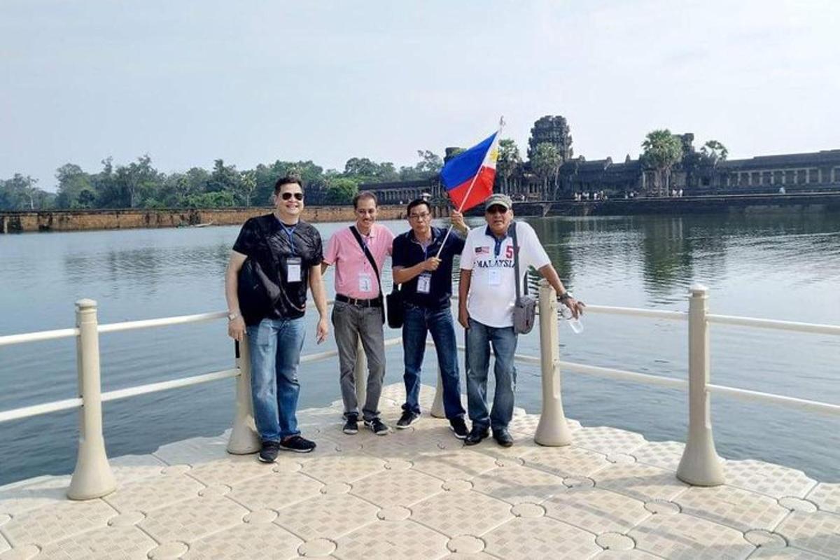 un grup de bărbați care stau lângă o întindere de apă