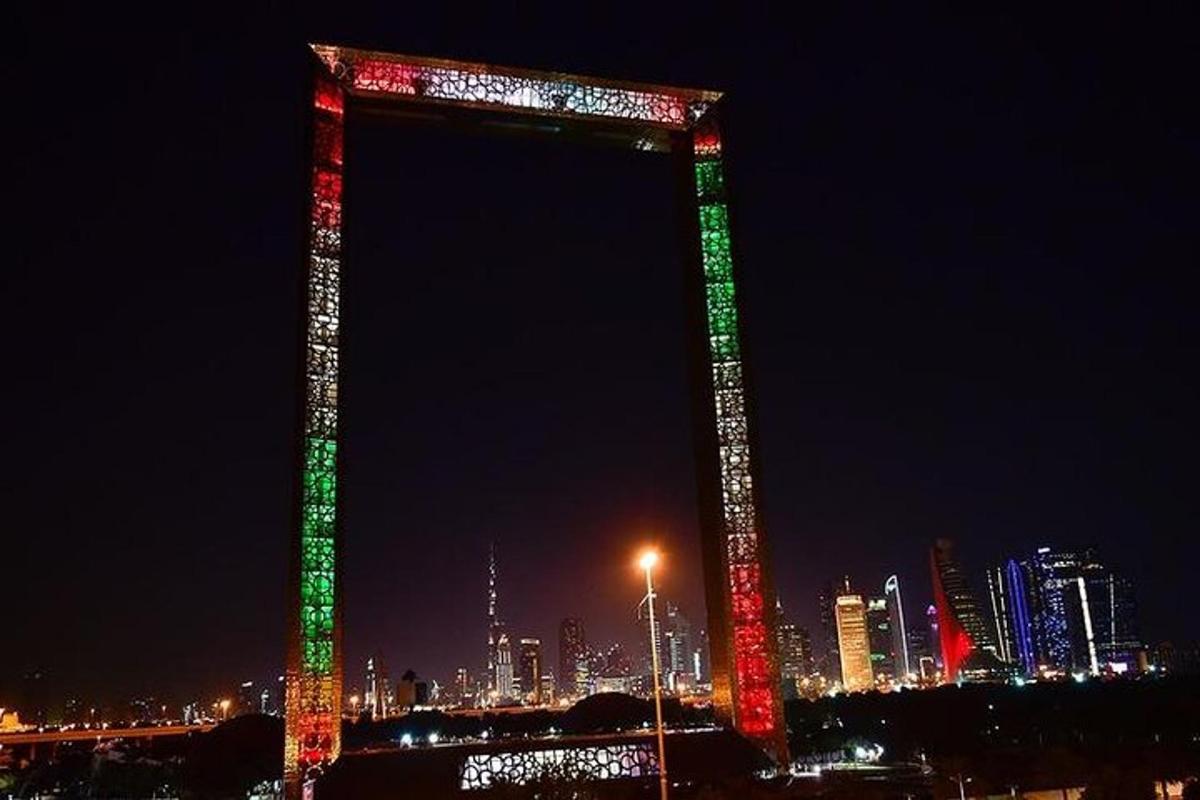 una torre iluminada en una ciudad por la noche