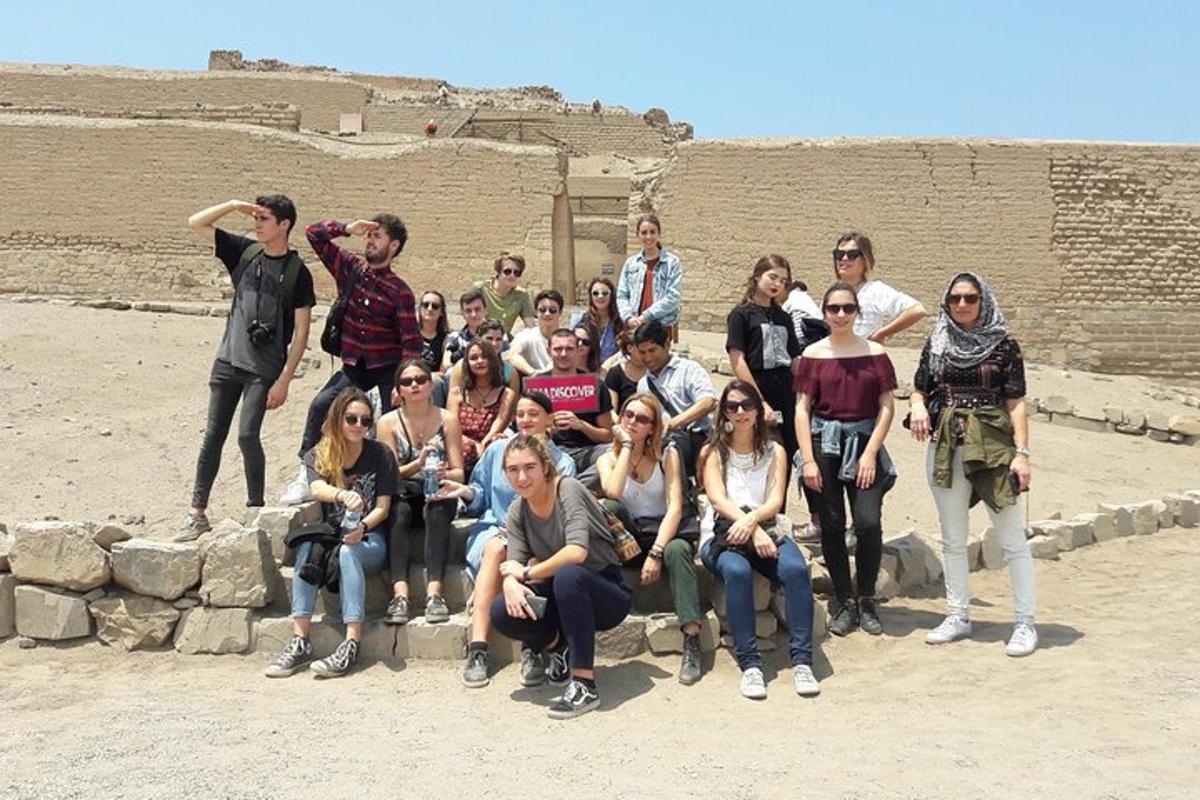 a group of people posing for a picture in front of a ruin