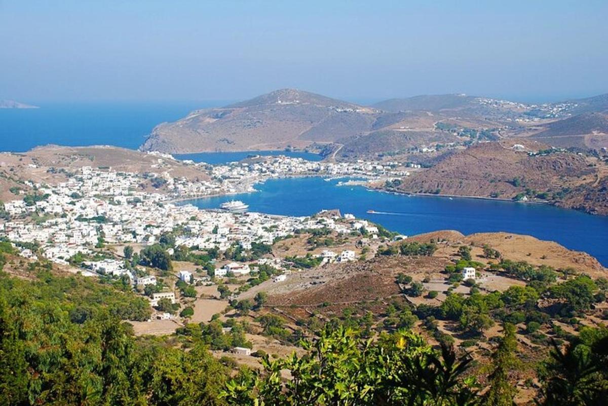 uma vista de uma cidade em uma colina com um corpo d'água