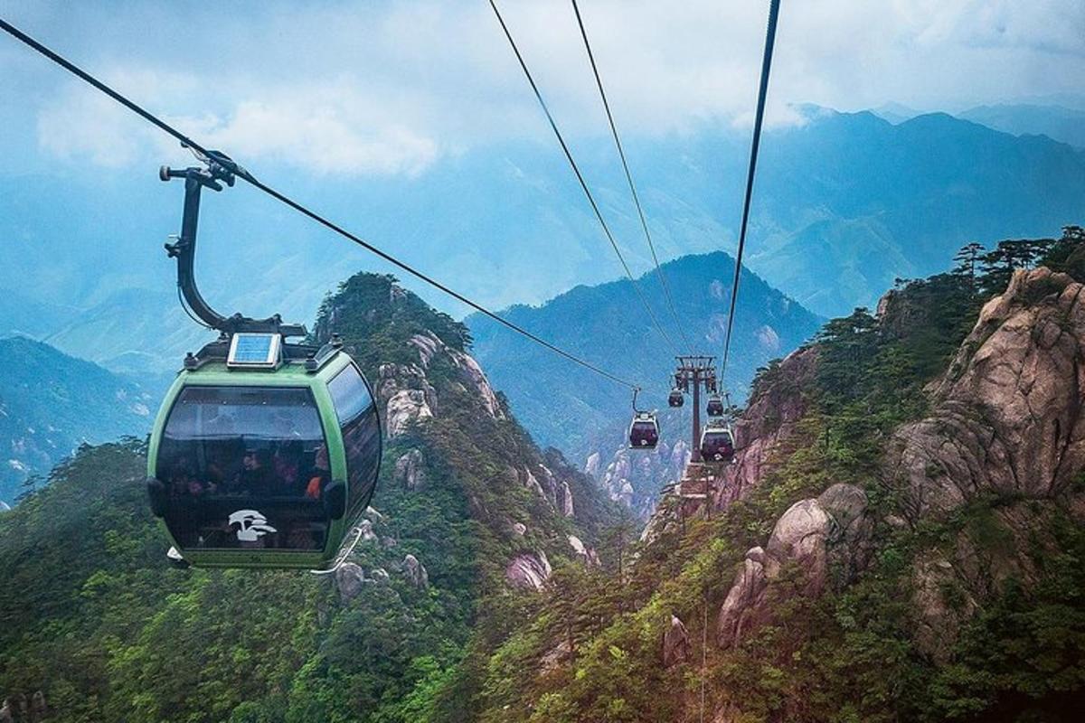 una gondola che vola sopra una montagna con delle persone a bordo