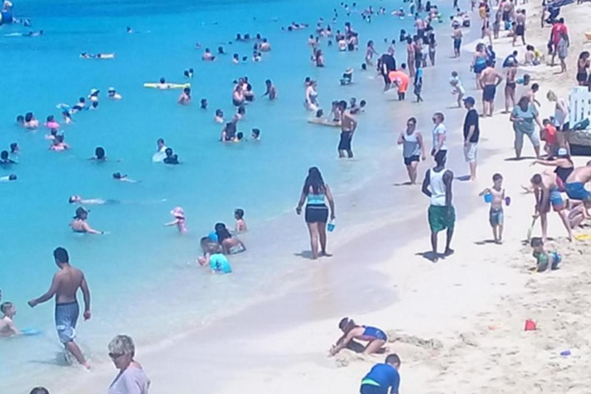 o mulțime de oameni în apă pe plajă