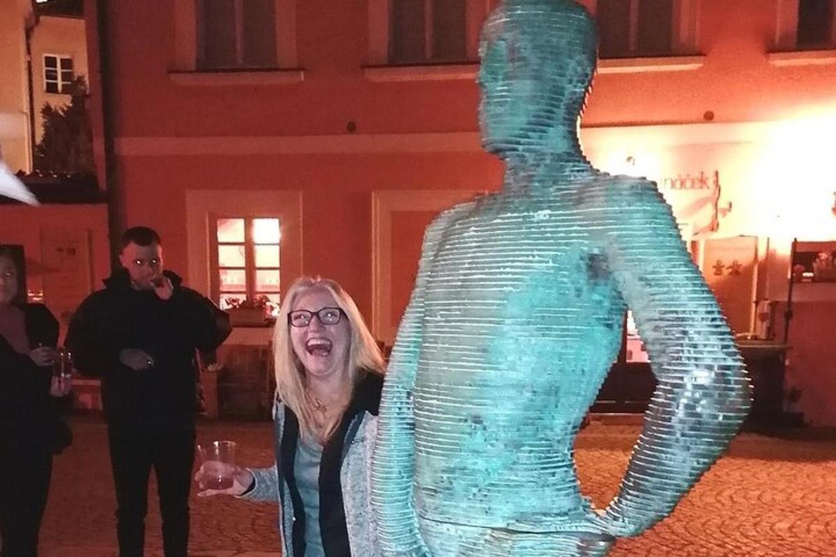 o femeie care stă lângă o sculptură din sticlă