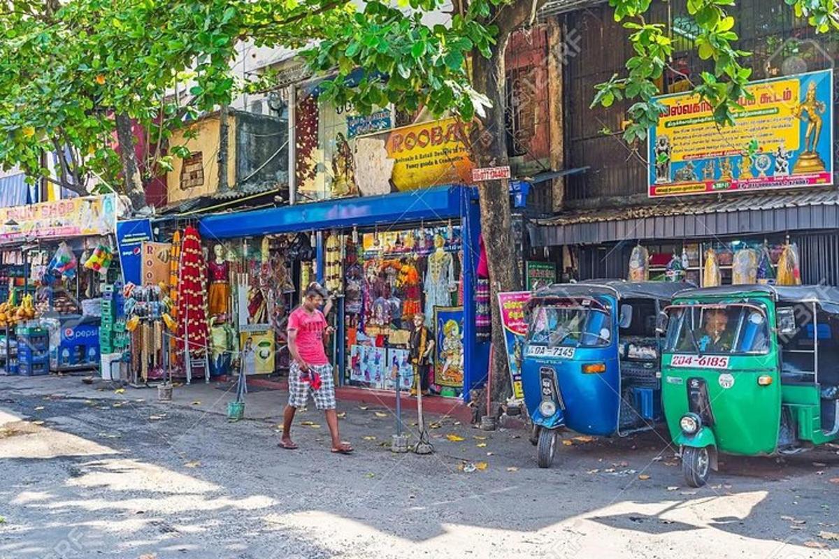 a man standing next to two rickshaws on a street