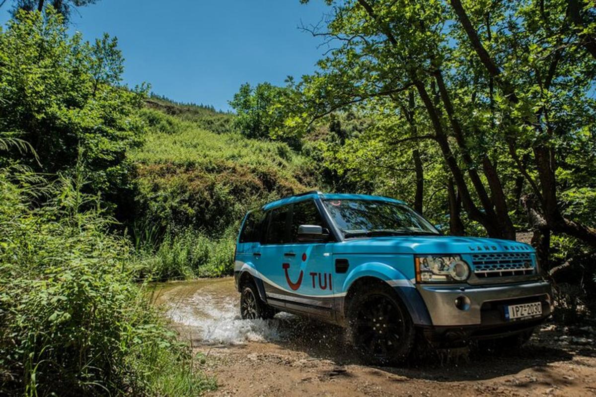 um jipe azul estacionado em uma estrada de terra