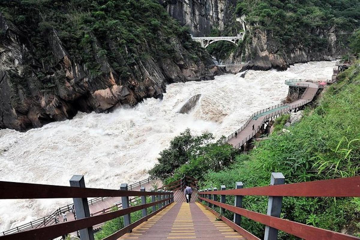 seseorang yang berjalan di atas jambatan di sebelah sungai