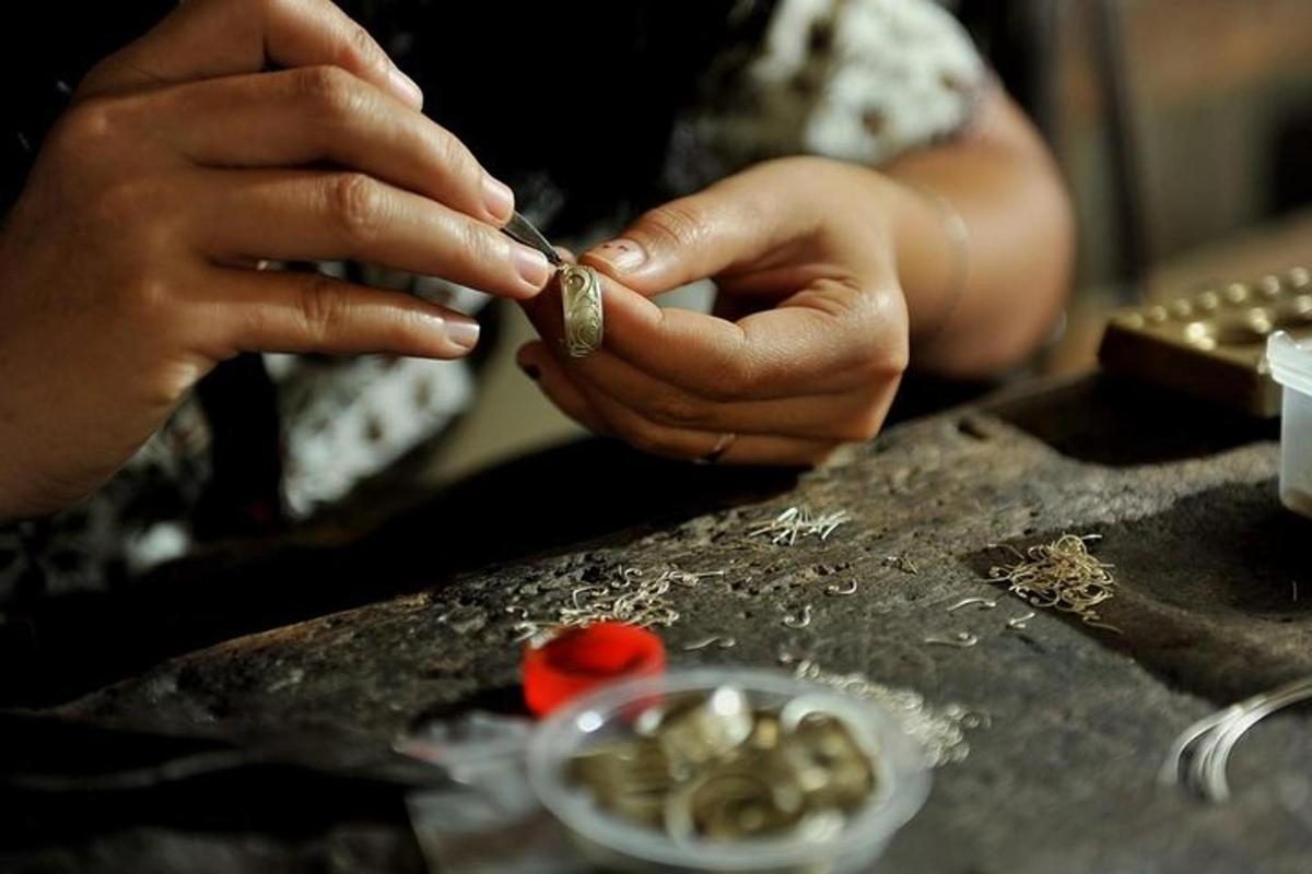 a woman is cutting a piece of metal on a table