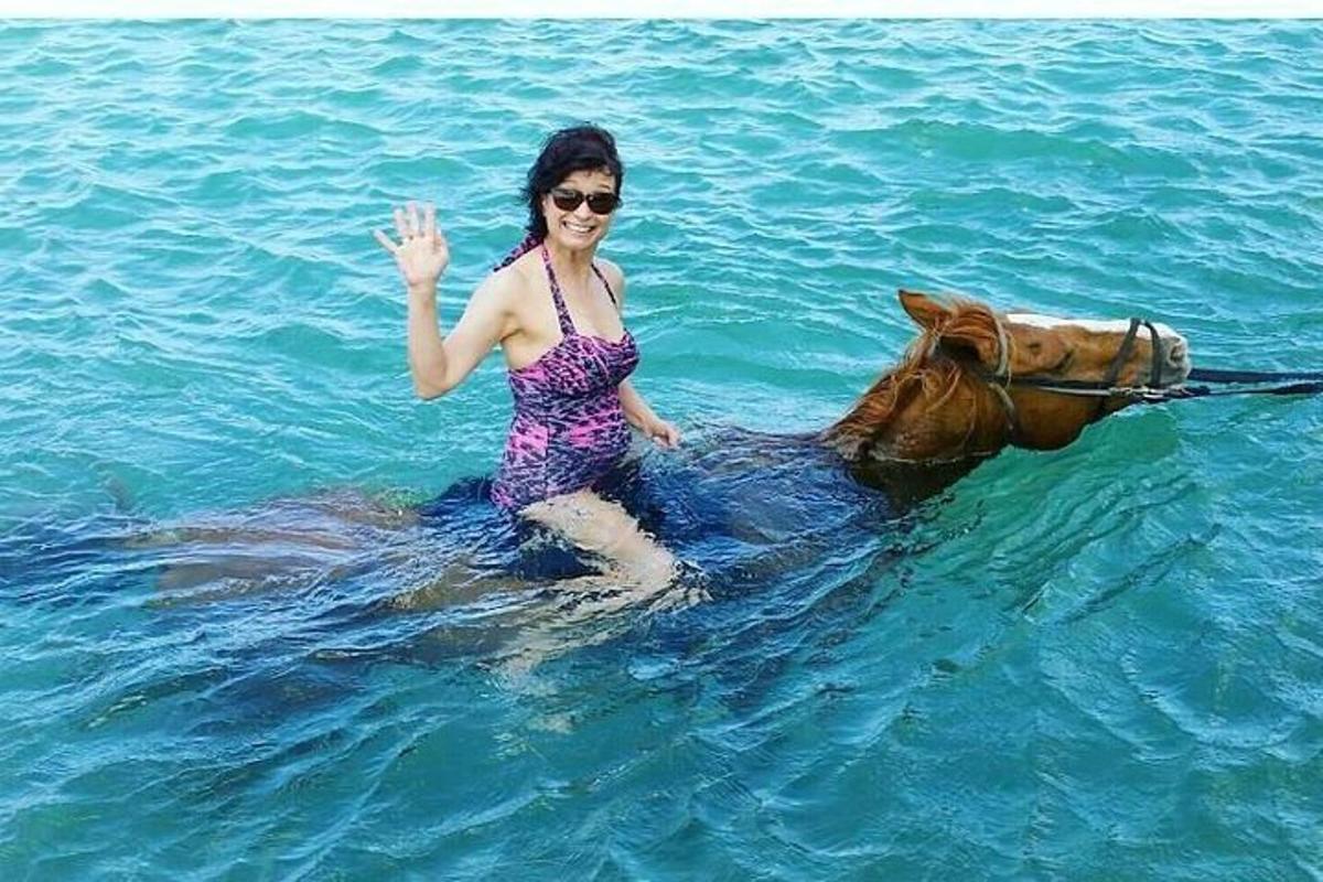 una donna in acqua con un cavallo in acqua