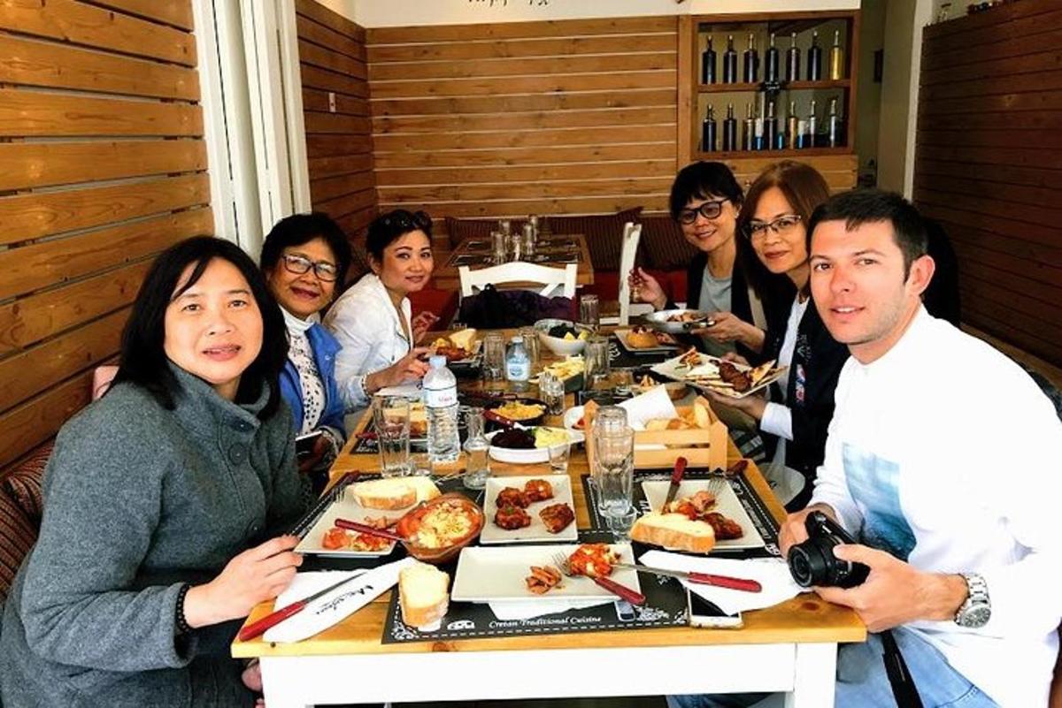 テーブルの周りに座って食事をとる人々のグループ