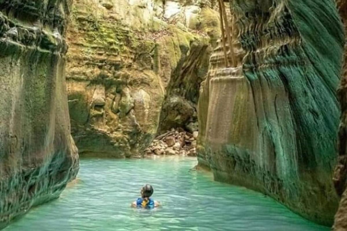 a person in a pool of water in a cave