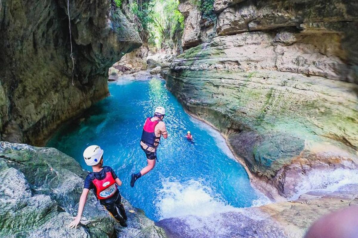 due persone che saltano in un fiume in un canyon