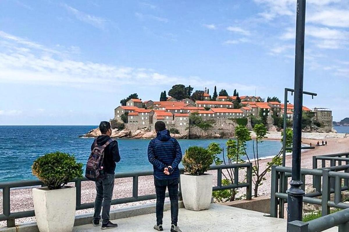 Dos personas de pie en un muelle mirando el océano.