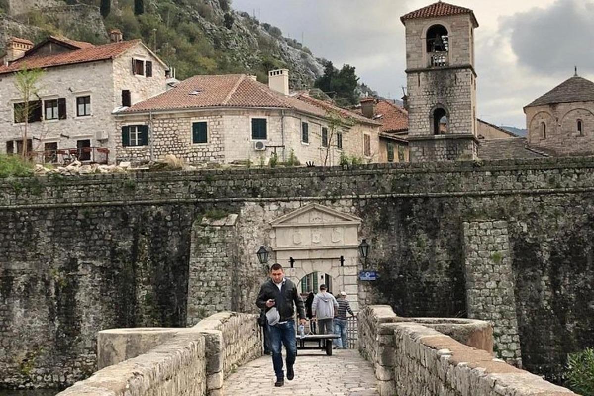 a man walking across a stone bridge