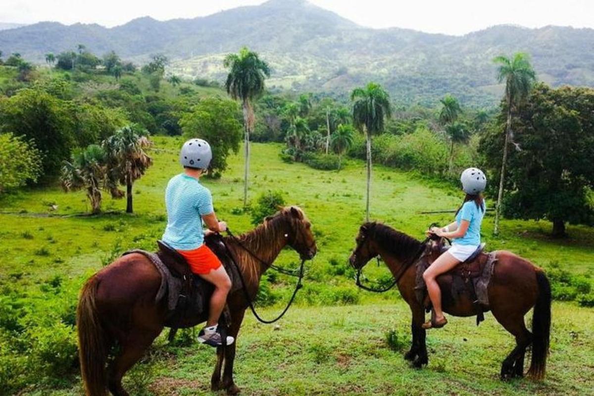 two people riding on horses in a field
