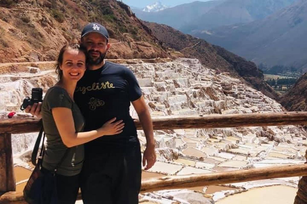un uomo e una donna in piedi sulla cima di una montagna