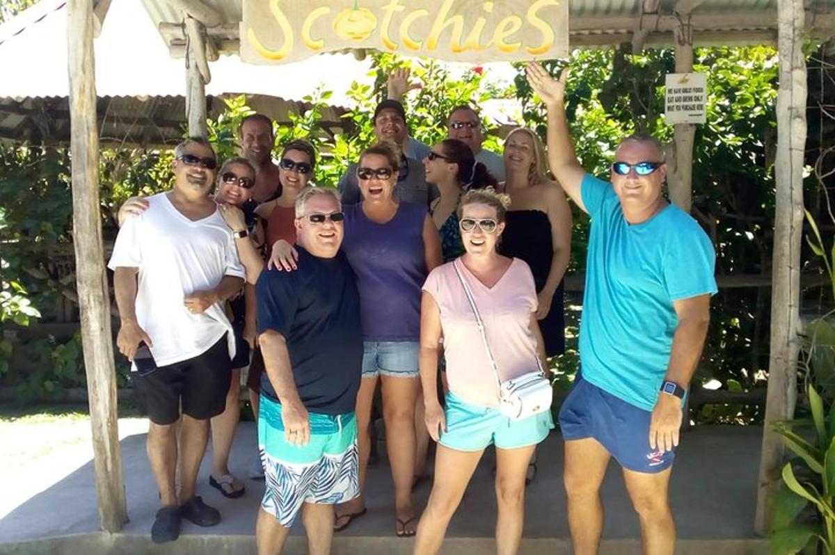 en gruppe mennesker som poserer for et bilde under et skilt