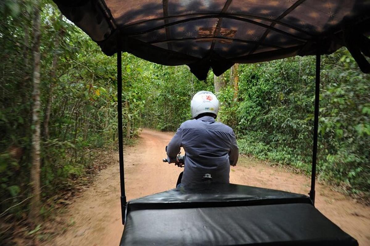 uma pessoa andando em um veículo em uma estrada de terra