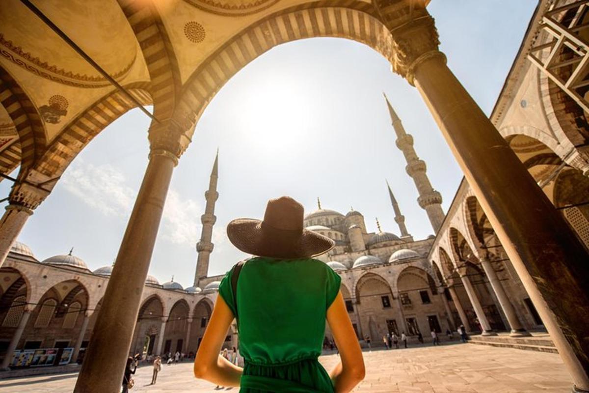 a person wearing a hat looking at a mosque