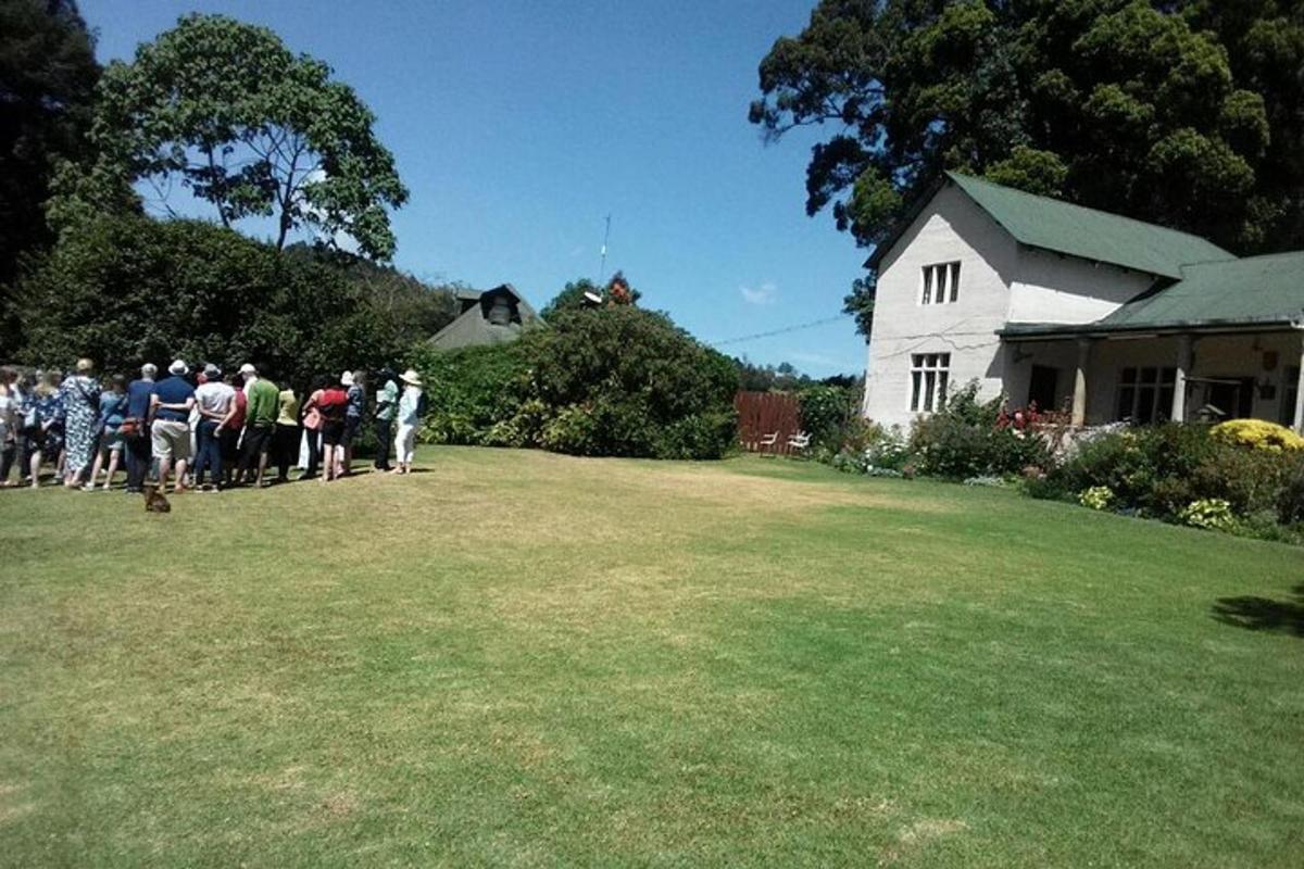 um grupo de pessoas em pé em frente a uma casa branca