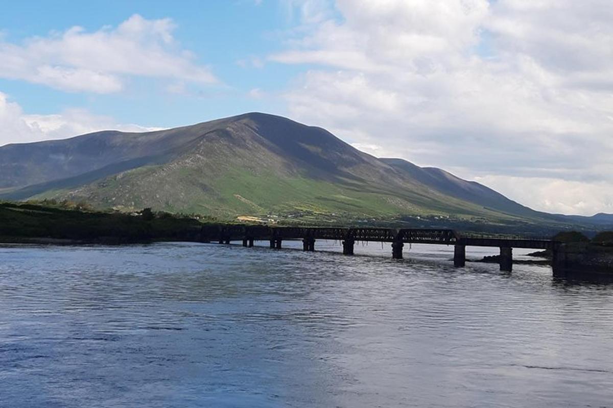 un ponte sopra un fiume con una montagna sullo sfondo
