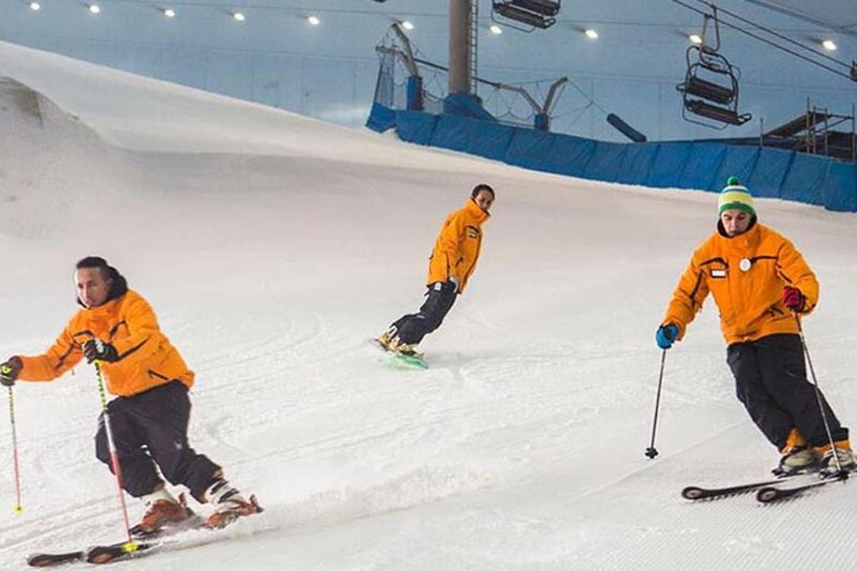 three men are skiing down a ski slope