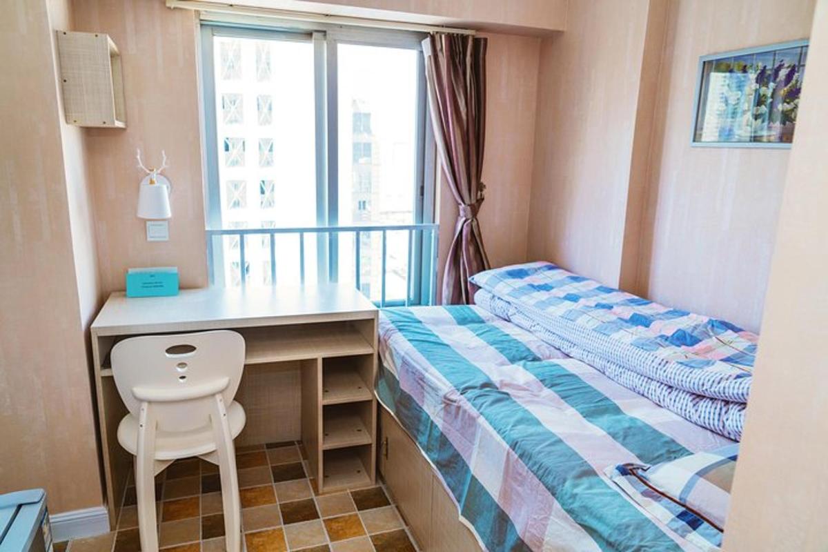 a small bedroom with a bed and a desk