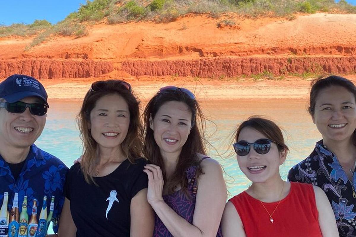a group of people posing for a picture on the beach