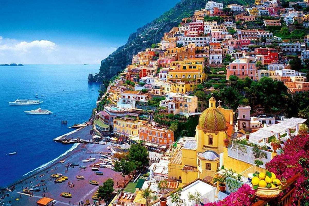 a view of a town on a hill next to the ocean