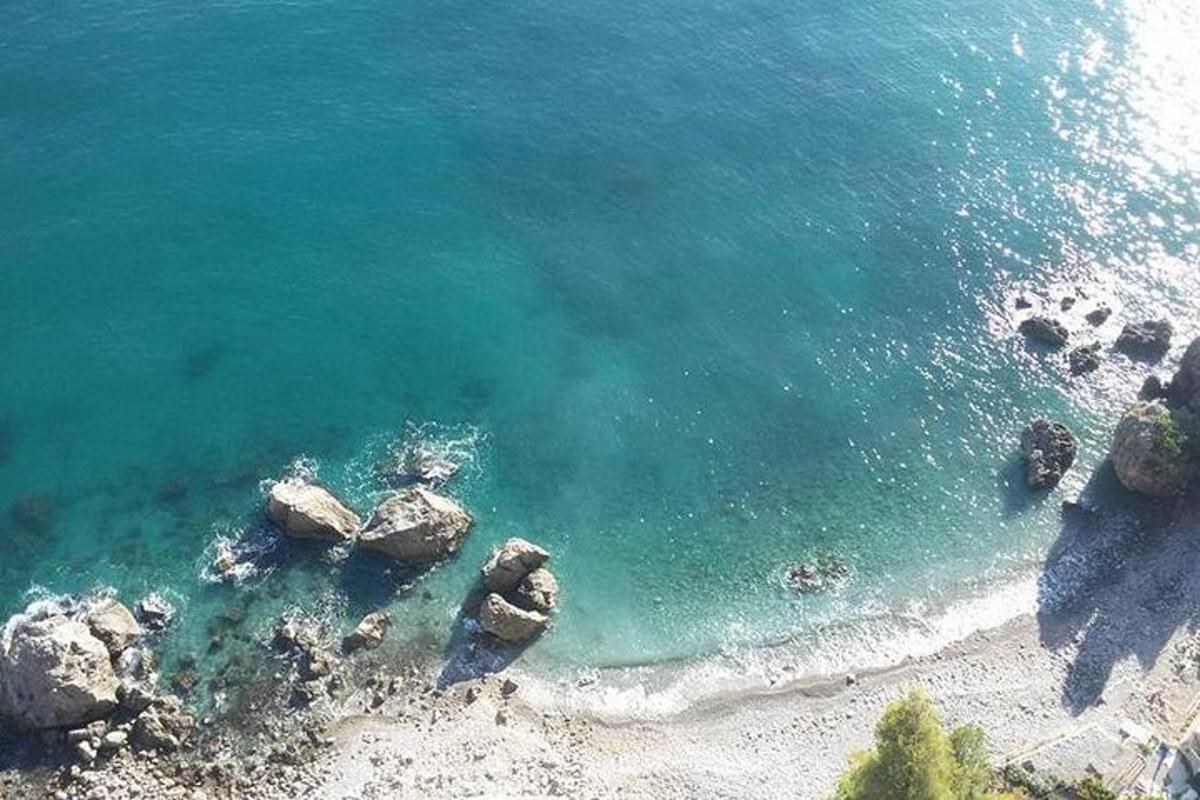 an aerial view of a beach with rocks in the water