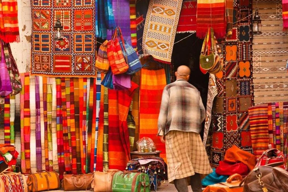 un uomo che cammina in un mercato con tessuti colorati