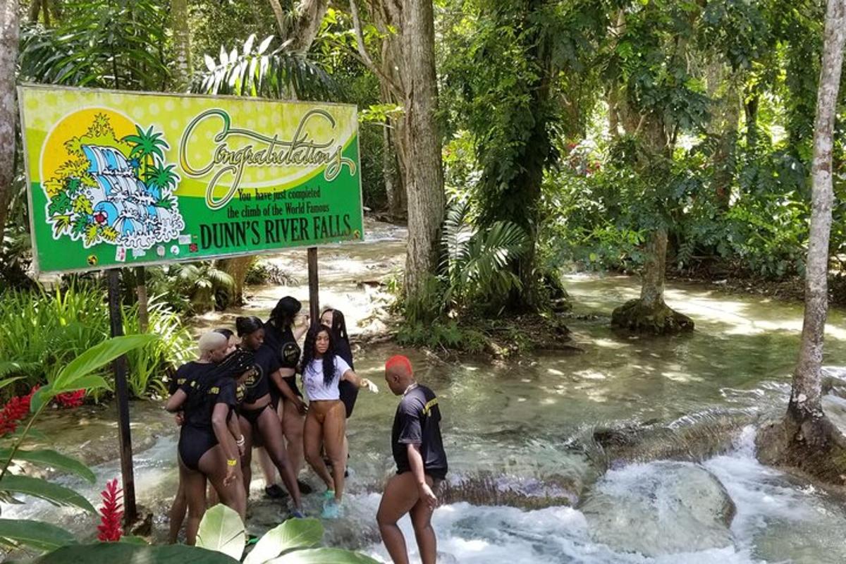 a group of people standing in a river with a sign