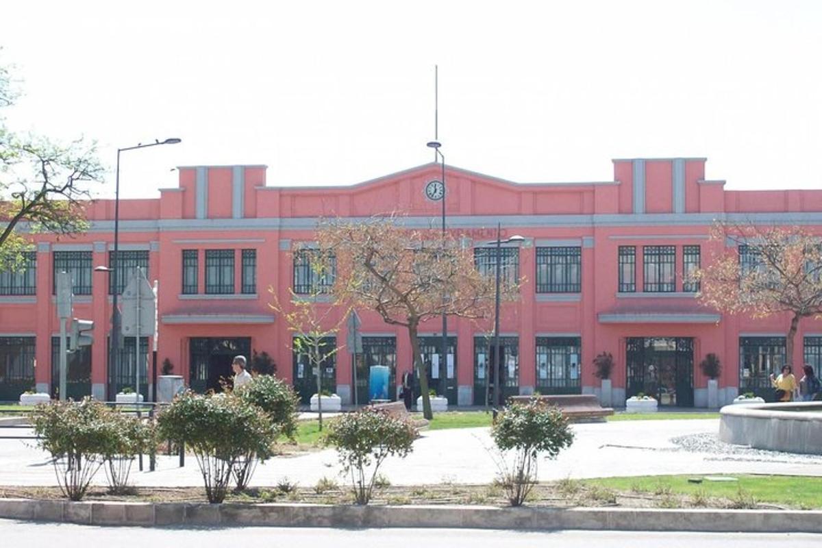 un grande edificio rosso con alberi di fronte