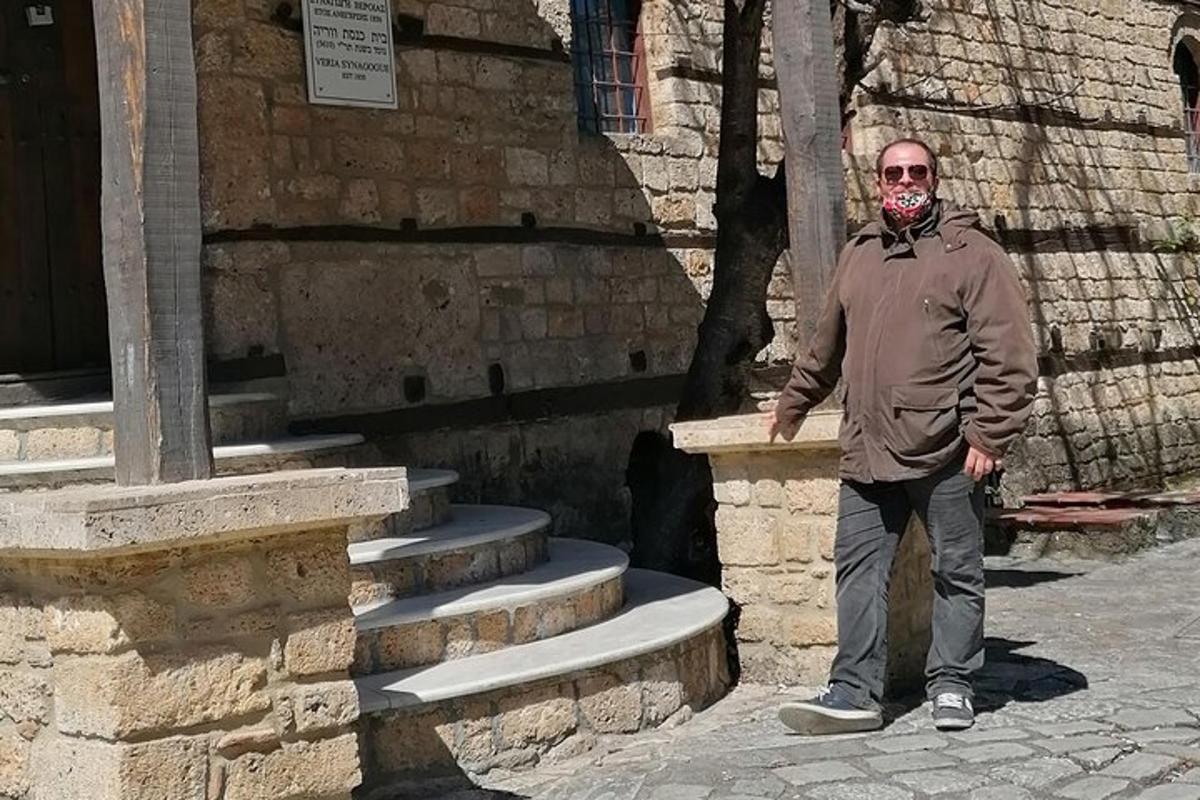 un home dret davant d'un edifici de pedra